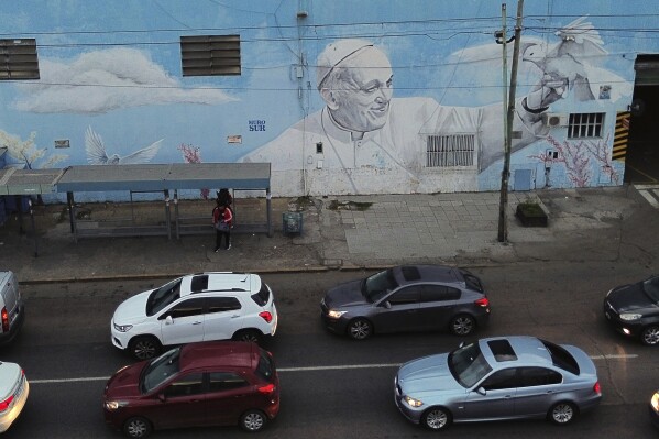 Vehicles drive past a mural of the late Pope Francis in Buenos Aires, Argentina Monday, April 21, 2025. (AP Photo/Mario De Fina)