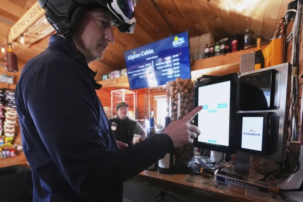 Skier Bill Eppich, of Hanover, Mass., uses a computer display to order lunch at the Alpine Cabin, a mid-slope refreshment stop, at Black Mountain, Friday, March 14, 2025, in Jackson, N.H. (AP Photo/Charles Krupa)