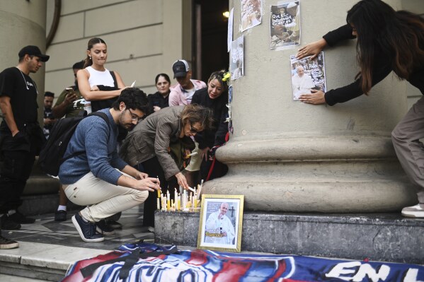 Faithful light candles for the late Pope Francis at the Cathedral in Buenos Aires, Argentina, Monday, April 21, 2025. (AP Photo/Mario De Fina)