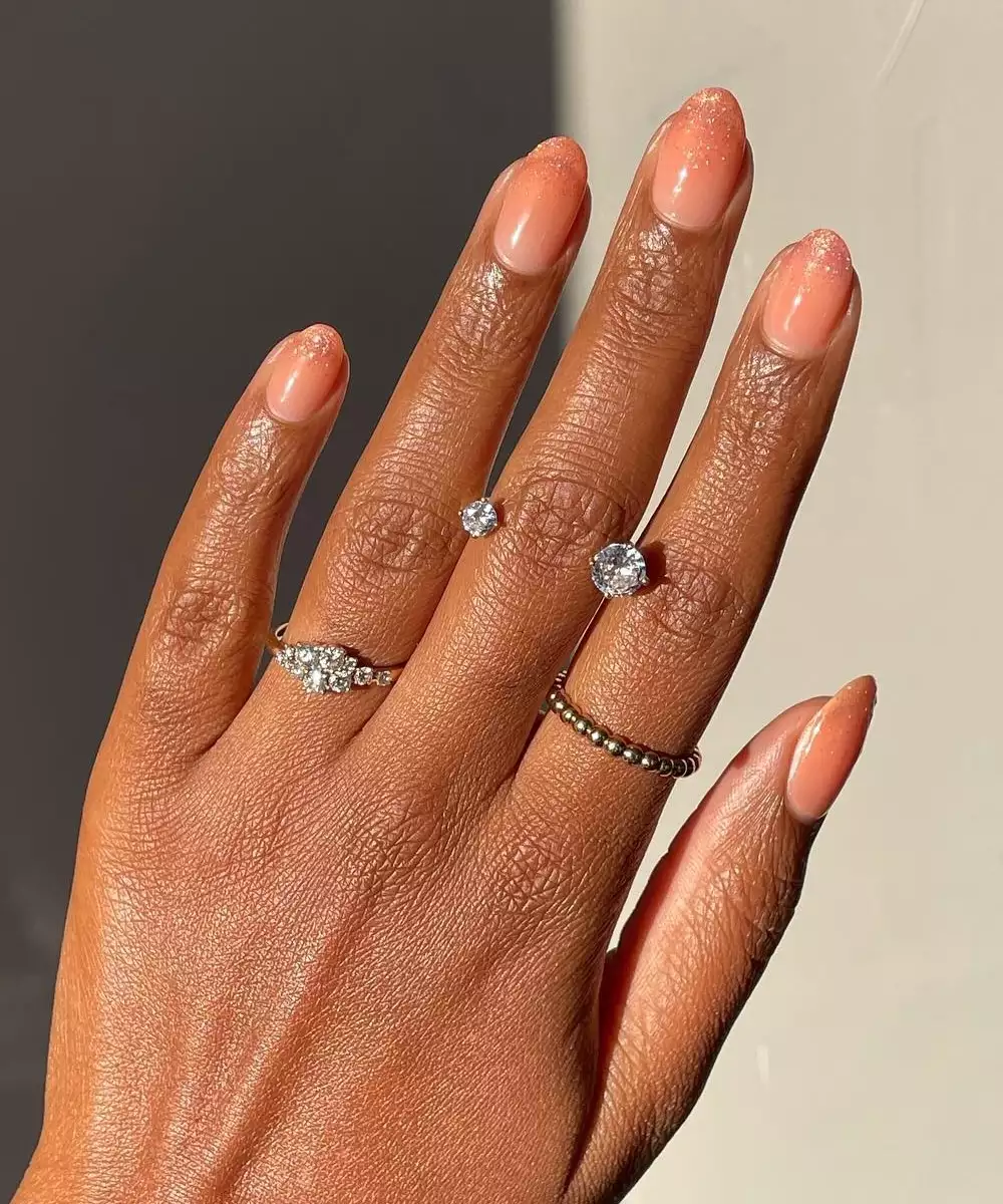 peach manicure with glitter tips