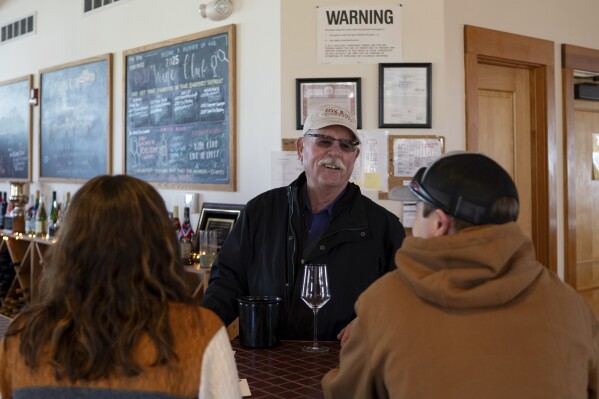 Scott Osborn, owner of Fox Run Vineyards, chats with customers Friday, March 21, 2025, in Penn Yan, N.Y. (Natasha Kaiser via AP)