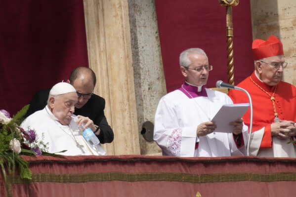 Pope Francis, left, sips water as he appears at the central lodge of St. Peter's Basilica to bestow the Urbi et Orbi (Latin for to the city and to the world) blessing at the end of the Easter mass presided over by Cardinal Angelo Comastri in St. Peter's Square at the Vatican Sunday, April 20, 2025. (AP Photo/Gregorio Borgia)