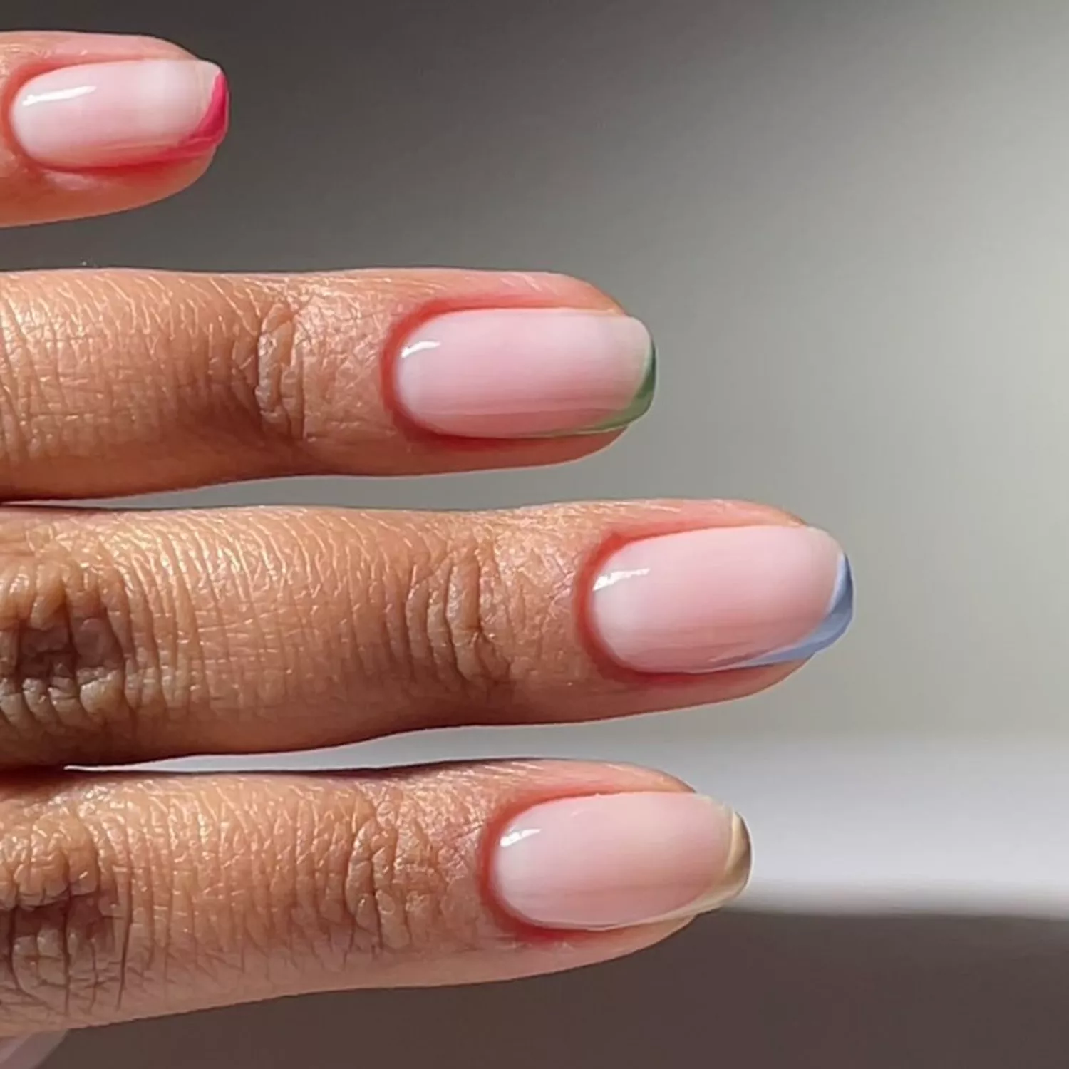 Micro asymmetric pastel French tips with a milky pale pink base