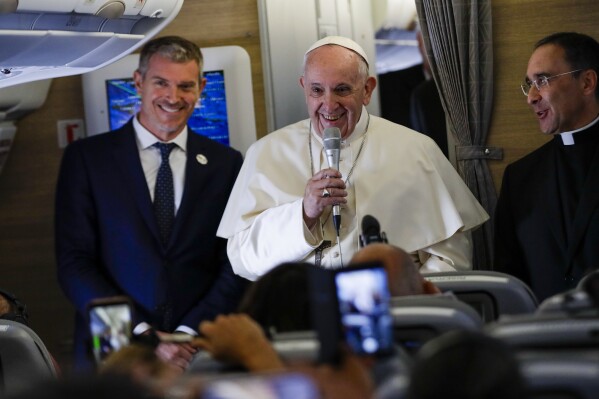 Pope Francis is flanked by his spokesperson Matteo Bruni, left, as he addresses journalists during his flight from Rome to Maputo, Wednesday, Sept. 4, 2019, where he will start his seven-day pastoral trip to Mozambique, Madagascar, and Mauritius. Pope Francis acknowledged his growing opposition within the conservative right-wing of the U.S. Catholic Church and said in off-hand remarks aboard the papal plane Wednesday it is 