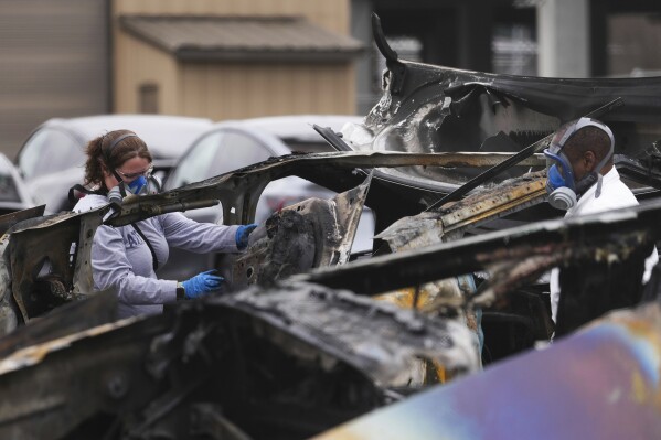 ATF investigators take apart and document a burned Tesla Cybertruck at a Tesla lot in Seattle, Monday, March 10, 2025. (AP Photo/Lindsey Wasson, File)