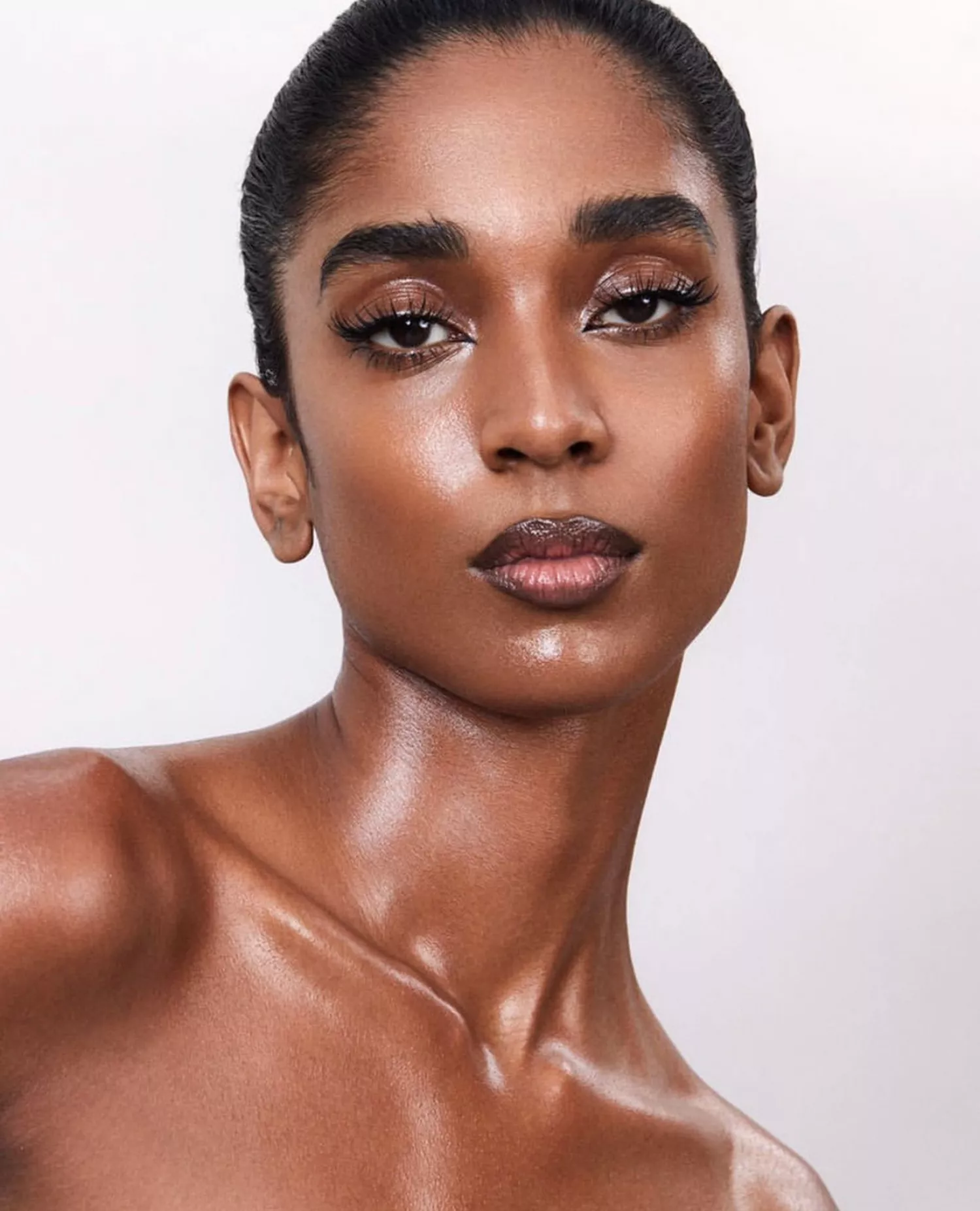 model poses wearing nude glossy makeup look