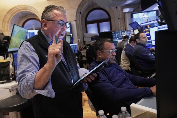 Trader John Bishop, left, works with colleagues on the floor of the New York Stock Exchange, Monday, April 21, 2025. (AP Photo/Richard Drew)