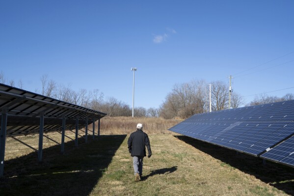Scott Osborn, owner of Fox Run Vineyards, walks through the vineyards past solar panels Friday, March 21, 2025, in Penn Yan, N.Y. (Natasha Kaiser via AP)
