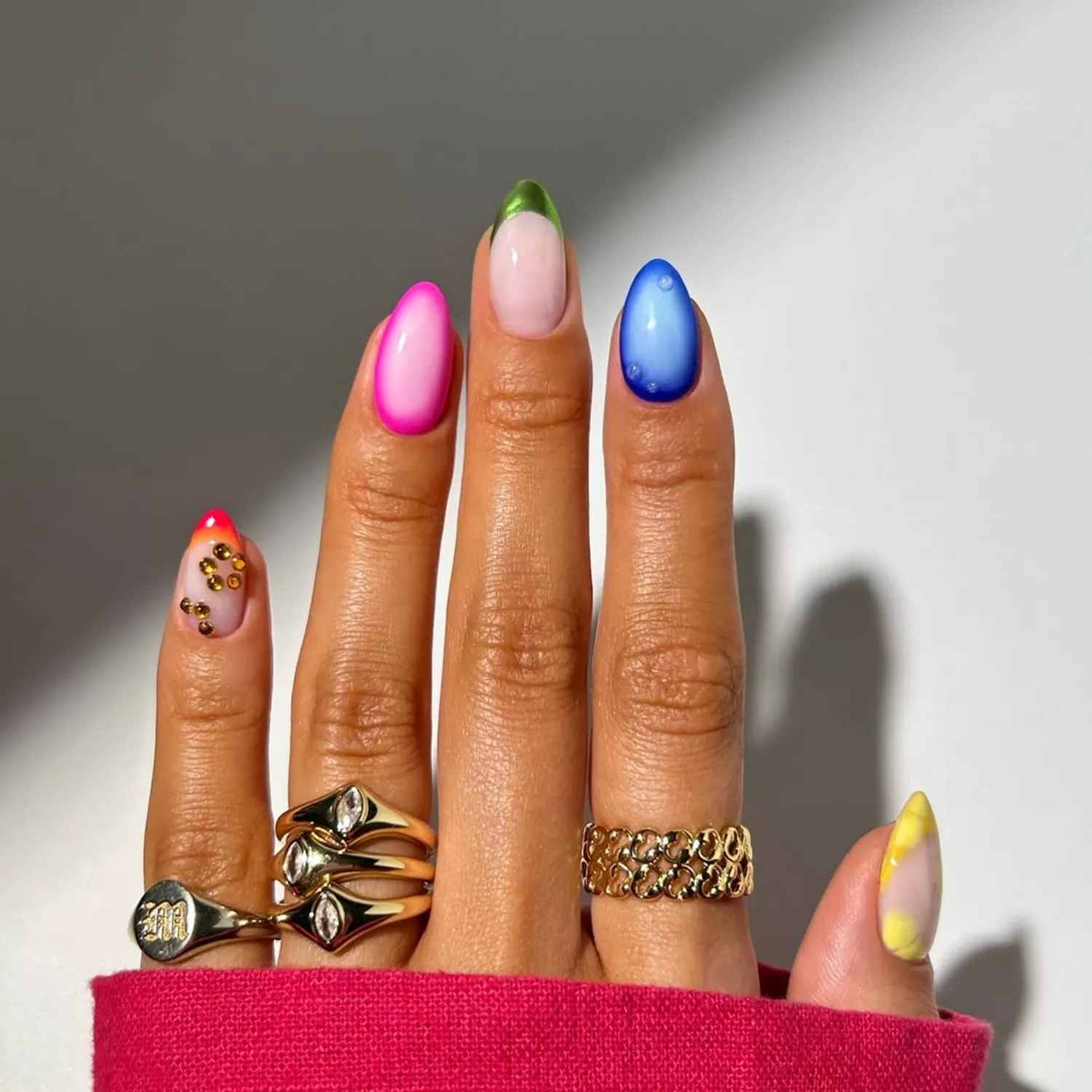 Manicure with colorful aura and dew drop designs, French tips, and gems