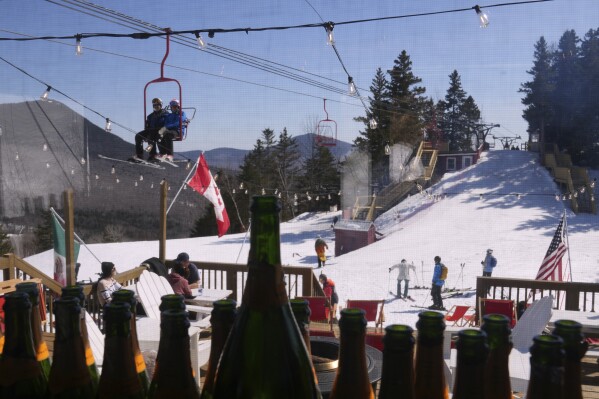 Empty champagne bottles are displayed at the Alpine Cabin, a mid-slope refreshment stop, as skiers ride the lift to the summit at Black Mountain, Friday, March 14, 2025, in Jackson, N.H. (AP Photo/Charles Krupa)