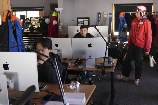 Erik Mogensen, right, founder of Entabeni Systems and the general manager of Black Mountain, talks with engineers in a temporary hardware and software technical center at the base of the mountain, Friday, March 14, 2025, in Jackson, N.H. (AP Photo/Charles Krupa)