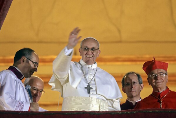 FOR USE AS DESIRED, YEAR END PHOTOS - FILE - Pope Francis waves to the crowd from the central balcony of St. Peter's Basilica at the Vatican, Wednesday, March 13, 2013. Cardinal Jorge Bergoglio, who chose the name of Francis is the 266th pontiff of the Roman Catholic Church. (AP Photo/Gregorio Borgia, File)
