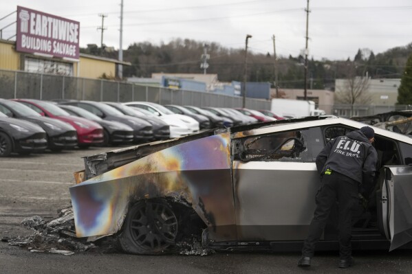 Un miembro del departamento de bomberos de Seattle inspecciona un Tesla Cybertruck en un estacionamiento de Tesla en Seattle, el lunes 10 de marzo de 2025. (AP Foto/Lindsey Wasson, Archivo)