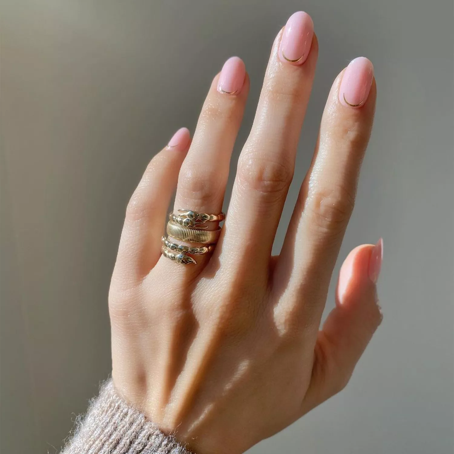 milky strawberry nails with gold cuticle detailing 
